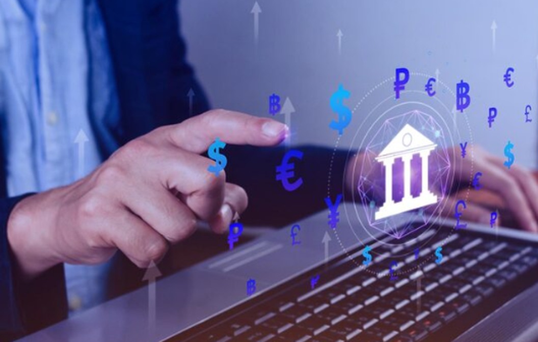 Alt text: A person using a laptop with digital currency symbols and a bank icon, representing the concept of Open Banking in the UK and the integration of financial technology.